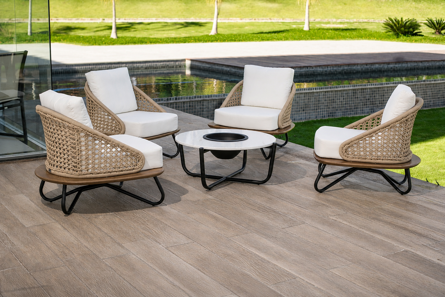 Conjunto de poltronas em corda clara com mesa central ao lado da piscina